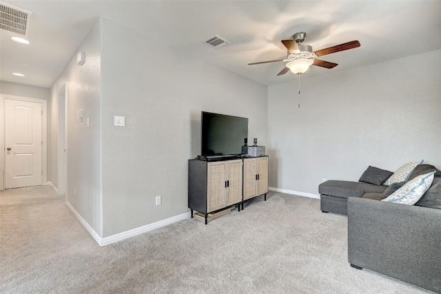 living room with visible vents, a ceiling fan, and light carpet