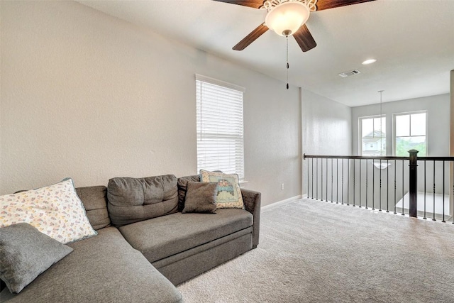 living room featuring a ceiling fan, baseboards, visible vents, and carpet