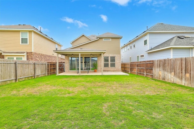 back of property with a fenced backyard, a yard, a patio area, and brick siding