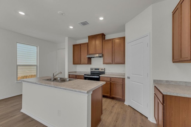201 Lucky Texan Rd, Jarrell, TX 76537 - kitchen featuring electric range, under cabinet range hood, brown cabinetry, light wood-type flooring, and recessed lighting