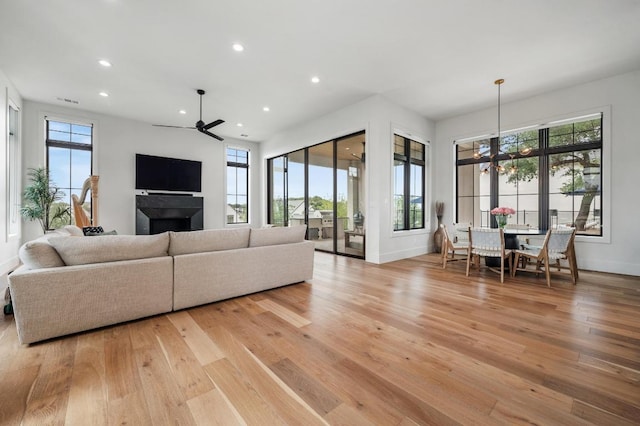 living room featuring light wood-type flooring, plenty of natural light, and ceiling fan
