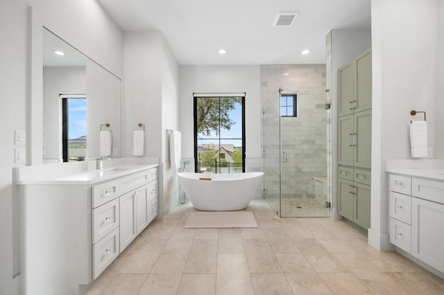 bathroom with recessed lighting, visible vents, a freestanding bath, and a stall shower