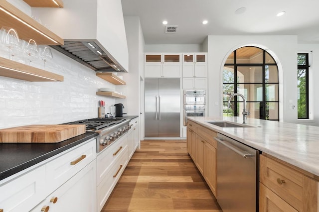 kitchen featuring open shelves, appliances with stainless steel finishes, a sink, plenty of natural light, and visible vents