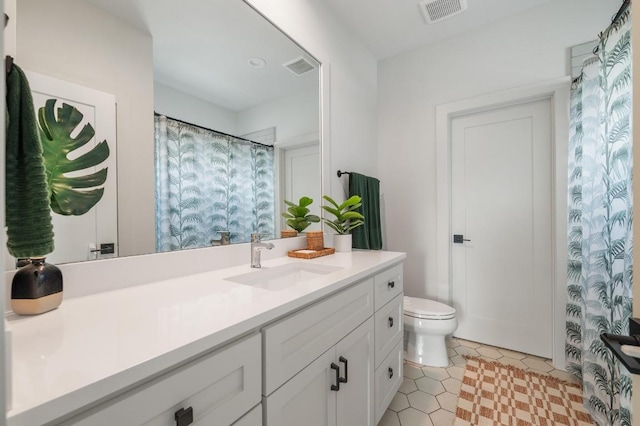 bathroom with toilet, tile patterned floors, visible vents, and vanity