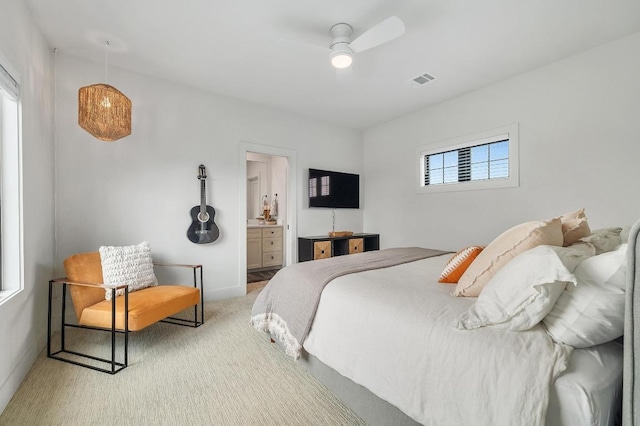 bedroom with ensuite bath, carpet floors, a ceiling fan, baseboards, and visible vents