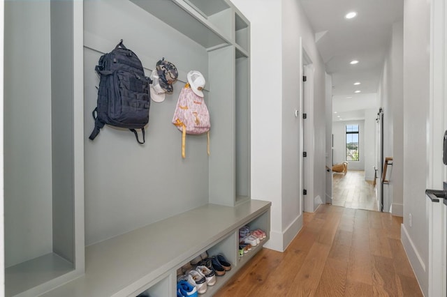 mudroom with recessed lighting, light wood-style floors, and baseboards