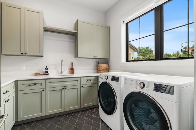 clothes washing area featuring a sink, dark tile patterned flooring, cabinet space, and independent washer and dryer