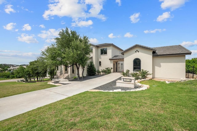 mediterranean / spanish-style home featuring stucco siding and a front lawn