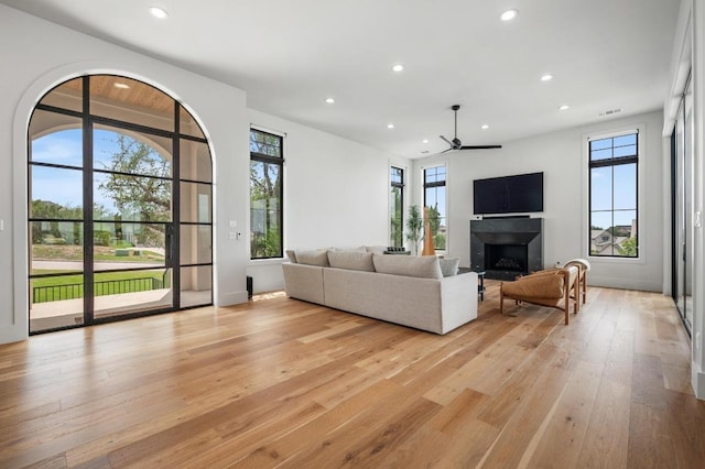 living room with recessed lighting, a ceiling fan, light wood finished floors, and a fireplace