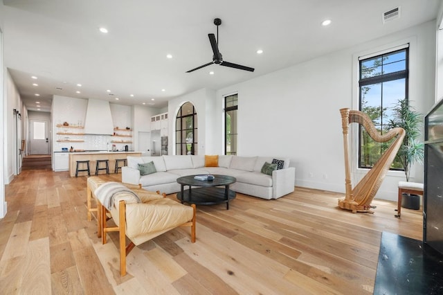 living area with recessed lighting, a ceiling fan, baseboards, light wood-type flooring, and visible vents