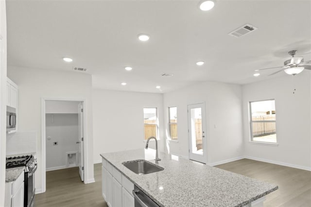kitchen featuring a sink, baseboards, stainless steel appliances, and visible vents