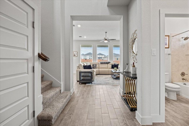 476 Wild Pecan Loop, Buda, TX 78610 - corridor featuring wood finished floors, stairs, baseboards, and a textured wall