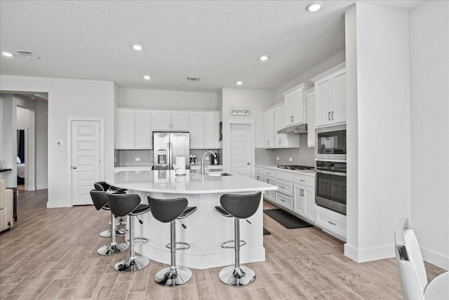 476 Wild Pecan Loop, Buda, TX 78610 - kitchen with appliances with stainless steel finishes, a sink, under cabinet range hood, tasteful backsplash, and recessed lighting