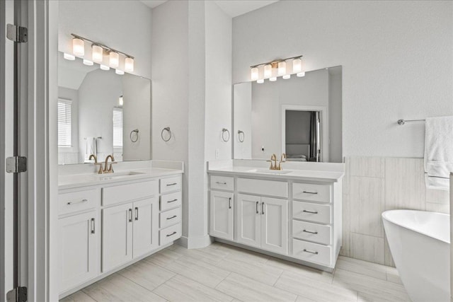 476 Wild Pecan Loop, Buda, TX 78610 - bathroom with two vanities, a freestanding bath, and tile walls