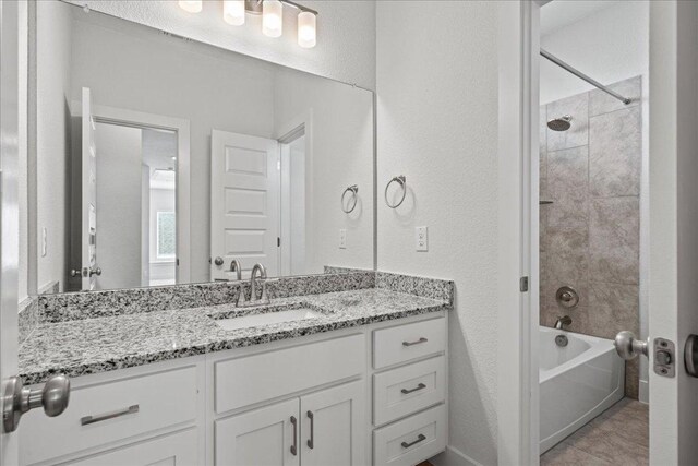 476 Wild Pecan Loop, Buda, TX 78610 - bathroom with vanity, bathtub / shower combination, a textured wall, and tile patterned flooring