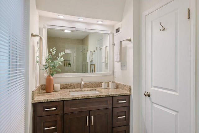 bathroom with vanity, a shower stall, and visible vents