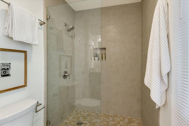 full bath featuring a tile shower and toilet