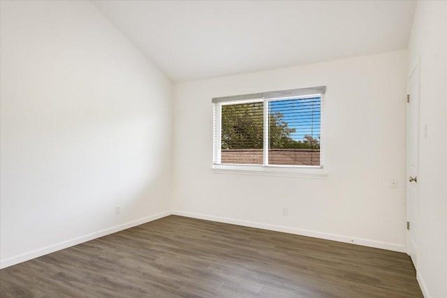 empty room with baseboards, lofted ceiling, and wood finished floors
