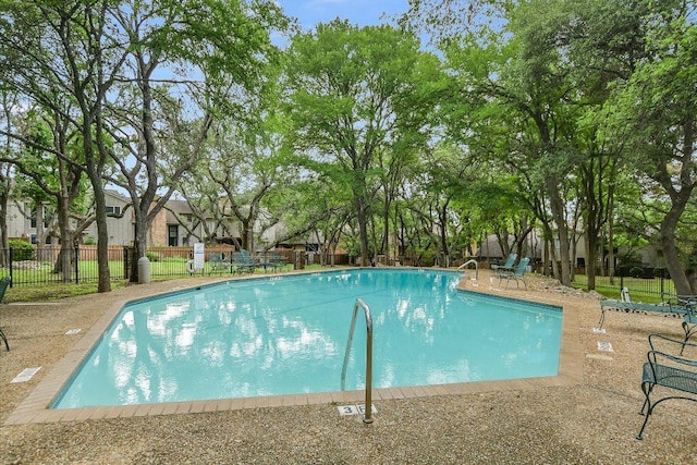 pool with a patio and fence