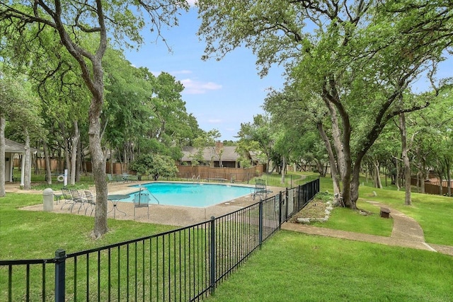 community pool featuring a yard and fence