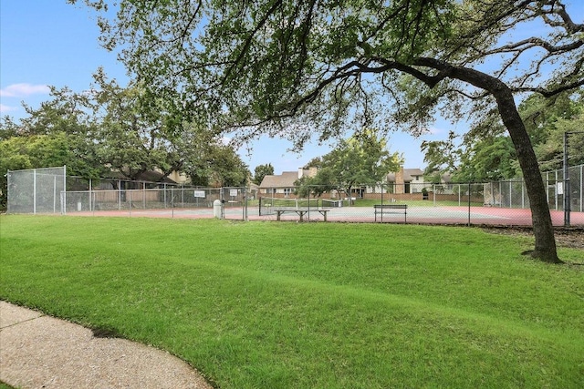 surrounding community featuring fence, a yard, and a tennis court