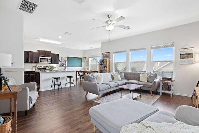 living room with visible vents, dark wood finished floors, ceiling fan, and baseboards