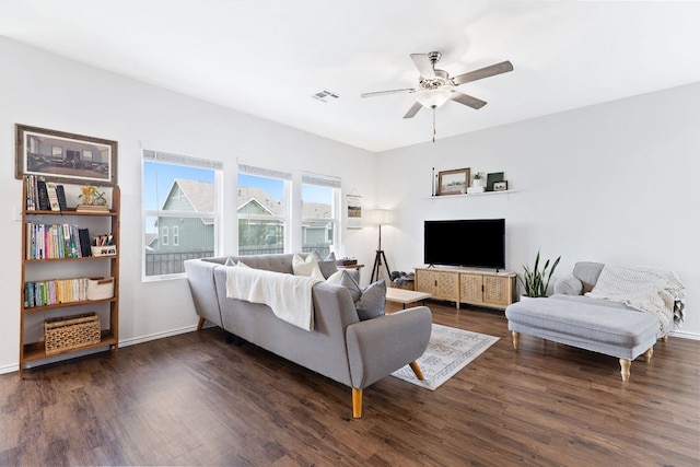 living area with visible vents, baseboards, ceiling fan, and dark wood-style floors