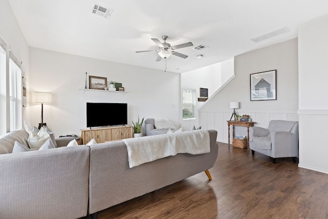 living area featuring ceiling fan, dark wood-type flooring, and visible vents