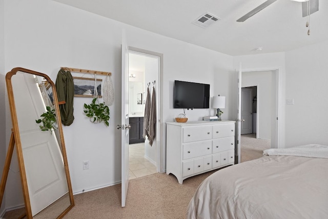 bedroom with ceiling fan, light carpet, ensuite bath, baseboards, and visible vents