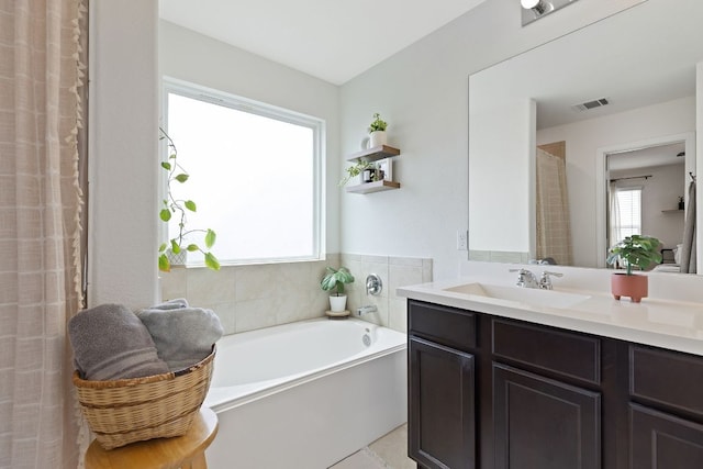 full bathroom with visible vents, a bath, and vanity