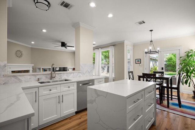 9417 Hopeland Dr, Austin, TX 78749 - kitchen with a sink, stainless steel dishwasher, crown molding, ceiling fan, and light wood-style flooring
