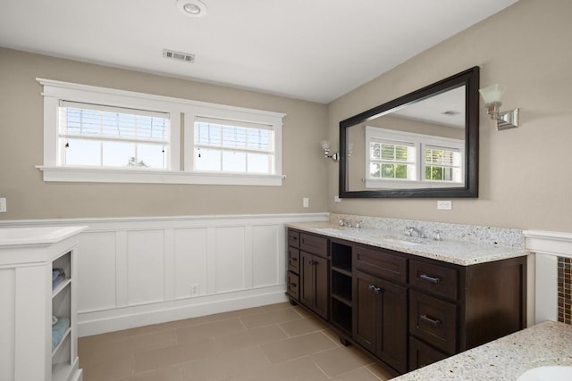 9417 Hopeland Dr, Austin, TX 78749 - bathroom with healthy amount of natural light, a wainscoted wall, vanity, tile patterned flooring, and a decorative wall