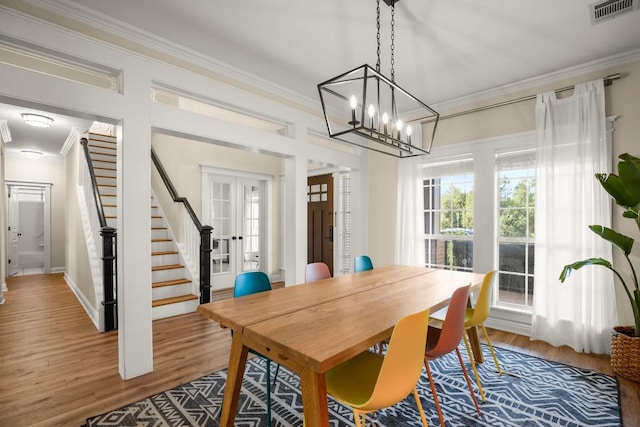 9417 Hopeland Dr, Austin, TX 78749 - dining room featuring stairs, wood finished floors, ornamental molding, a chandelier, and french doors
