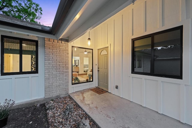 exterior entry at dusk with board and batten siding and brick siding