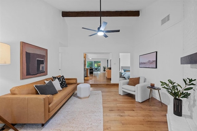 living room featuring ceiling fan, visible vents, high vaulted ceiling, and light wood-style floors