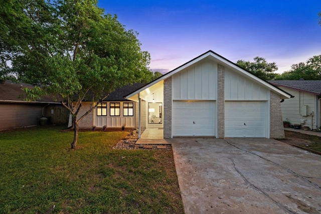 single story home with concrete driveway, board and batten siding, an attached garage, and brick siding
