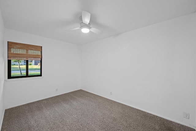 carpeted empty room featuring baseboards and ceiling fan