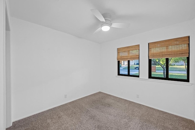 carpeted spare room with baseboards and ceiling fan