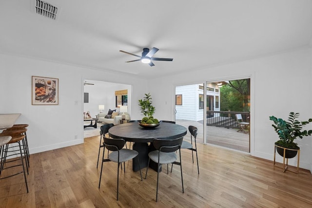 dining space featuring baseboards, a ceiling fan, light wood-style flooring, and visible vents
