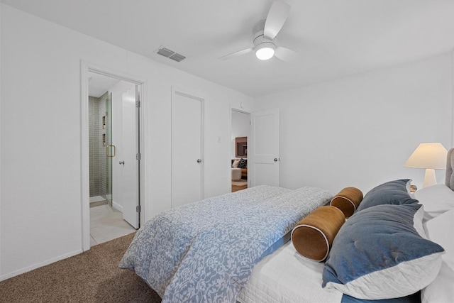 bedroom with visible vents, connected bathroom, ceiling fan, and light colored carpet