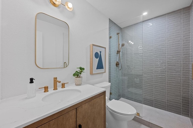 bathroom featuring vanity, toilet, and tiled shower
