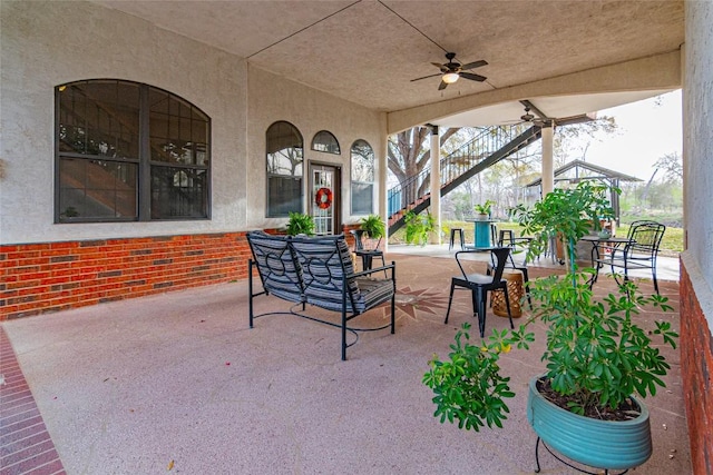 view of patio / terrace featuring stairway and ceiling fan