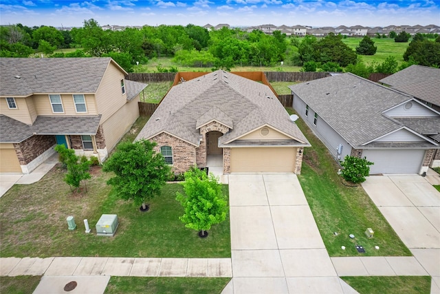 11904 Jamie Dr, Manor, TX 78653 - view of front facade with driveway, an attached garage, brick siding, a residential view, and roof with shingles