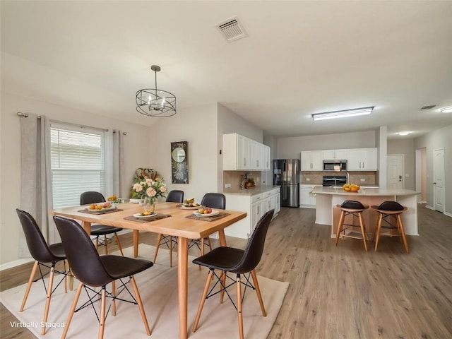 11904 Jamie Dr, Manor, TX 78653 - dining area featuring light wood-style flooring and a chandelier