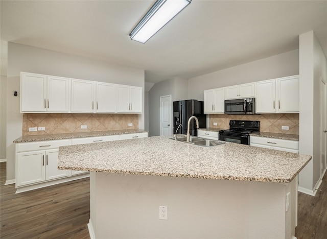 kitchen featuring white cabinetry, a sink, black appliances, and tasteful backsplash