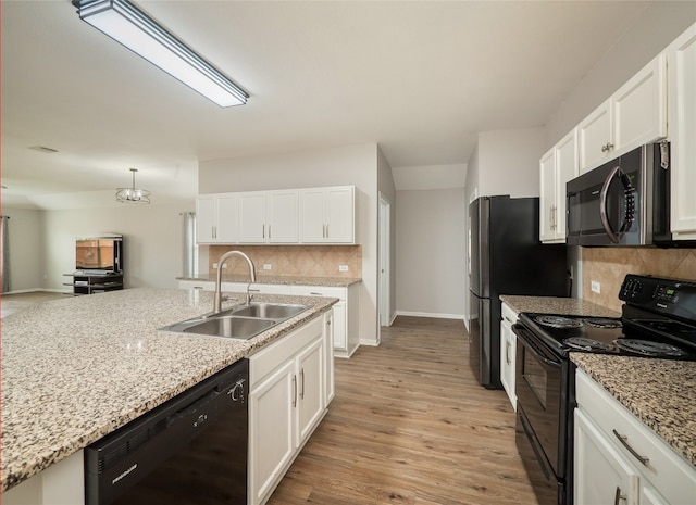 11904 Jamie Dr, Manor, TX 78653 - kitchen with black appliances, tasteful backsplash, white cabinets, and light stone countertops