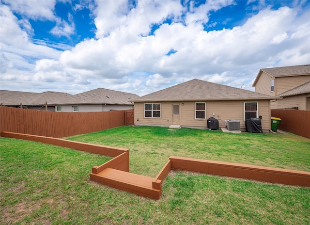 rear view of property featuring a fenced backyard, a lawn, and central AC