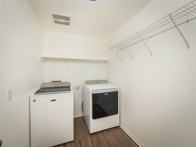 washroom featuring laundry area, visible vents, dark wood-style flooring, washer and dryer, and baseboards