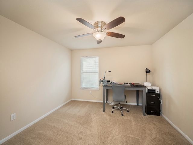 carpeted home office featuring baseboards and a ceiling fan