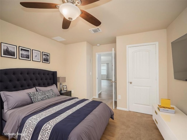 bedroom featuring light colored carpet, ceiling fan, visible vents, and baseboards